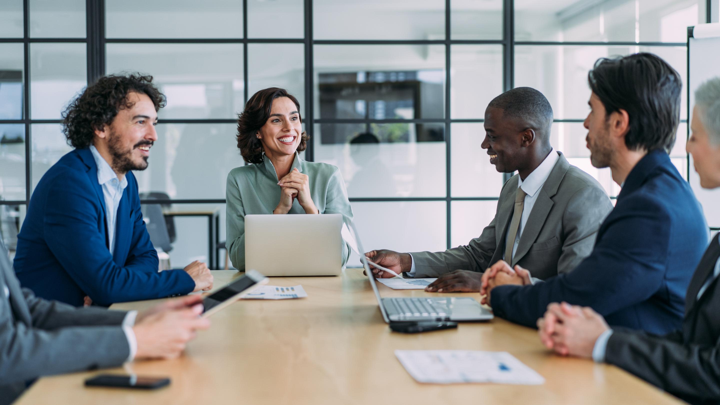 Business colleagues meeting around a conference table in a glass walled office