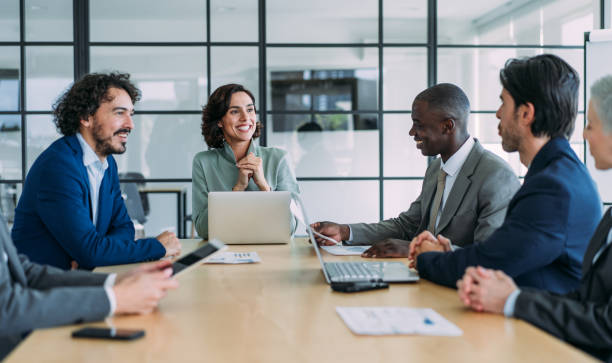 Business colleagues meeting around a conference table in a glass-walled office