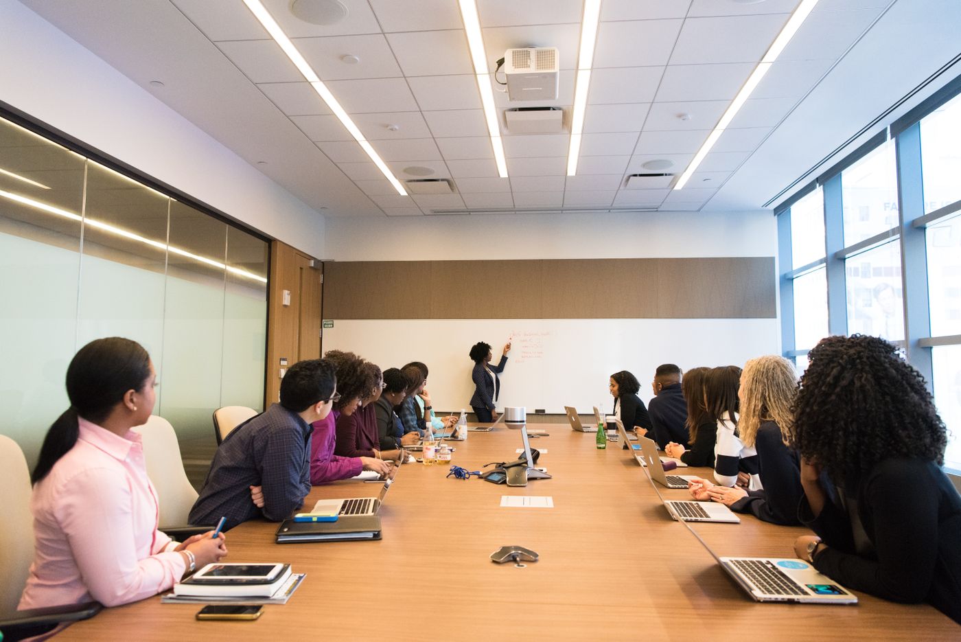 Woman leading a presentation to colleagues around a boardroom table
